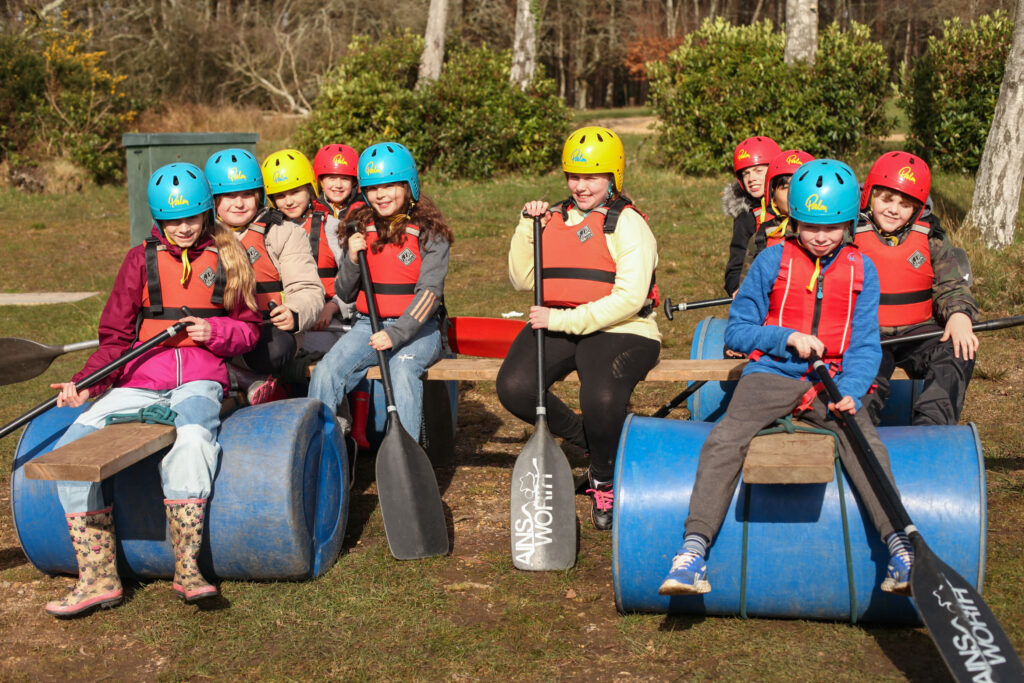 Young people sitting on a raft they have built at Avon Tyrrell. Picture: Nicola Harman.