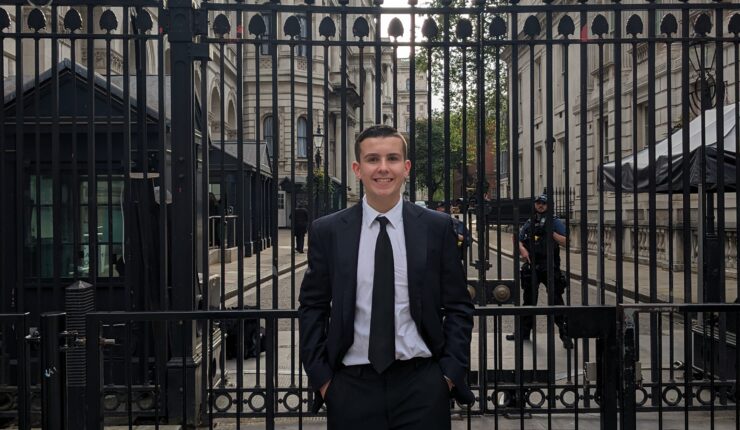 Fifteen-year-old #iwill ambassador Billy Curtis stands at the black gates to Downing Street.