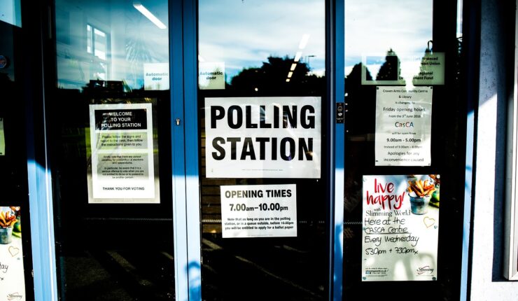The outside of a polling station, with posters in the window advertising the polling station.