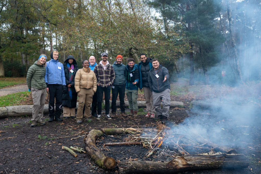 The Active Futures Cohort poses for a photo by the campfire.